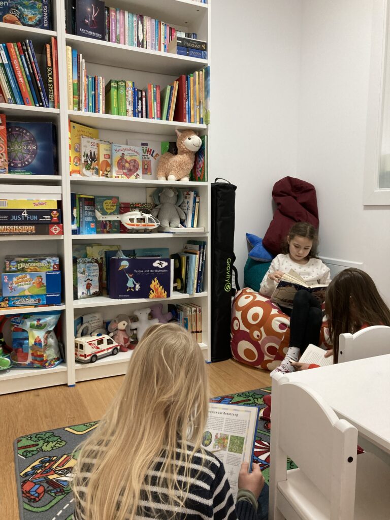 Niña sentada en un puf en la biblioteca infantil recién reformada.