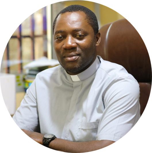 Ein Mann, der Direktor von Caritas Bamenda, auf einem Stuhl